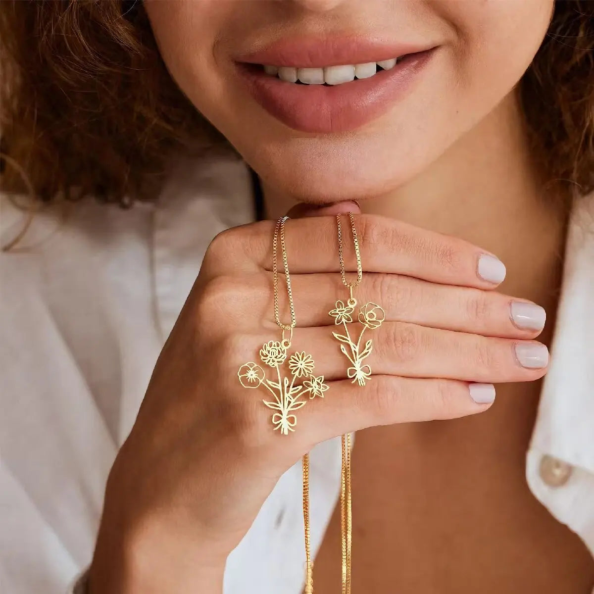 Custom gold birth flower bouquet pendant necklace featuring delicate cutout flowers tied with a ribbon bow