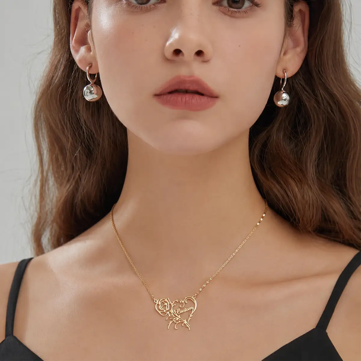 Custom gold rose heart name necklace featuring a cutout rose flower and vine heart with cursive name Custom inside